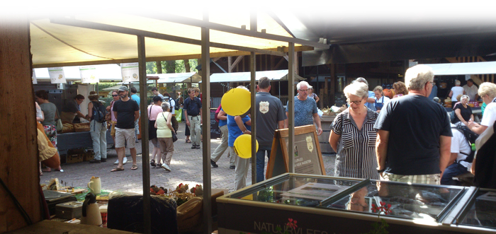 Foto van een boerenmarkt met bezoekers en kraampjes